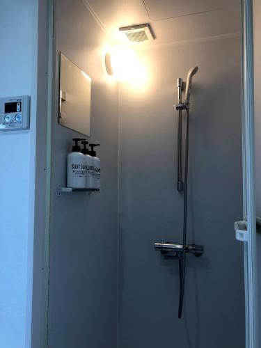 a bathroom with a shower with a light on the wall at Pension Kamifuji in Osaki