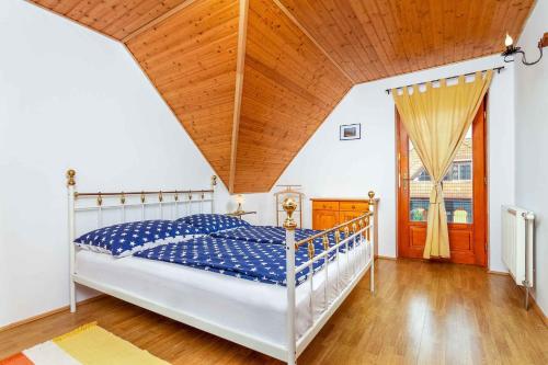 バラトンベレーニにあるHoliday home Balatonbereny 18059の木製の天井が特徴のベッドルーム1室(ベッド1台付)