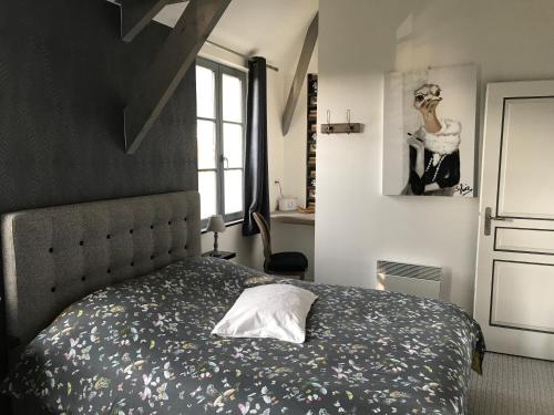 a bedroom with a bed with a black headboard at O Mylle Douceurs in Le Crotoy