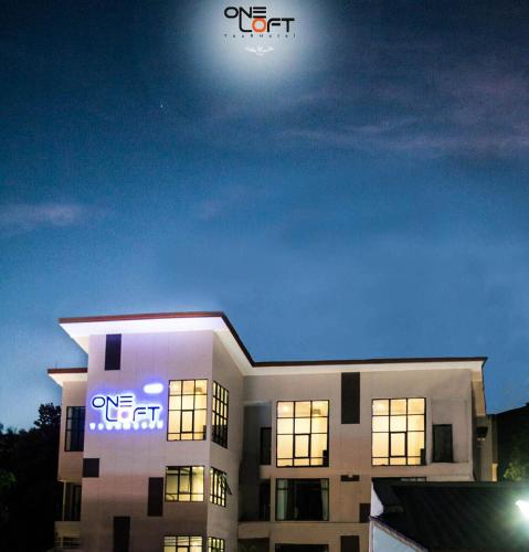 カロンビーチにあるOneLoft Hotelの夜間にホテルの看板が1つだけある建物