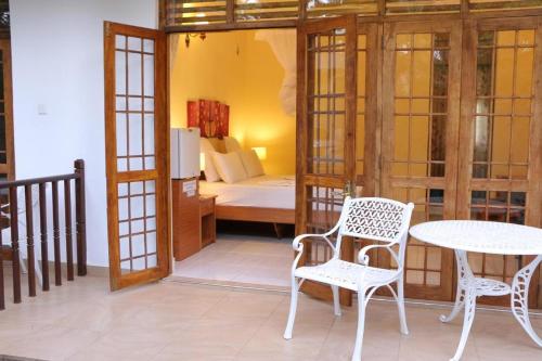 a room with a table and chairs and a bedroom at London Palace in Anuradhapura