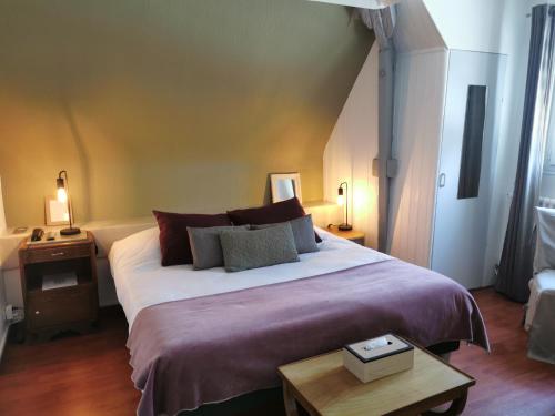 a bedroom with a large bed and a table at Hotel Restaurant Le Bosquet in Les Ponts-de-Cé
