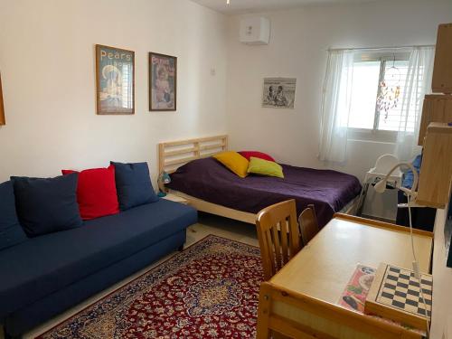 a room with a couch and a bed and a table at Acre sea view 11th floor apartment in ‘Akko