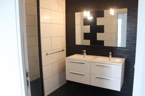 een badkamer met een wastafel en een spiegel bij L'AYMERAUDE in Messinhac