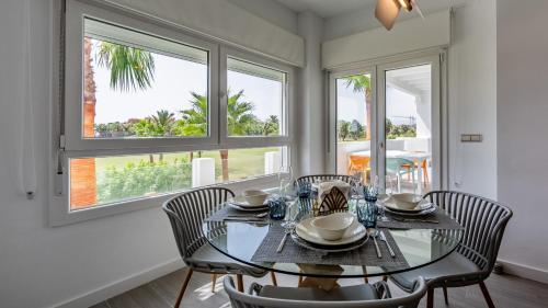 Homity Exclusive Playa Granada Beach & Golf - Marina Golf في موتريل: غرفة طعام مع طاولة وكراسي زجاجية