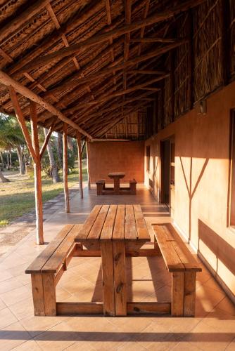 a wooden picnic table sitting under a wooden roof at Morrumbene Beach Resort in Morrumbene