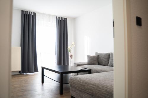 a living room with a couch and a coffee table at AP Hotel Mannheim Viernheim in Viernheim