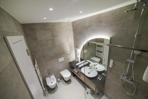 Baño con 2 lavabos y espejo en Hotel President, en Čapljina
