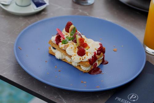 a piece of cake on a blue plate on a table at Hotel President in Čapljina