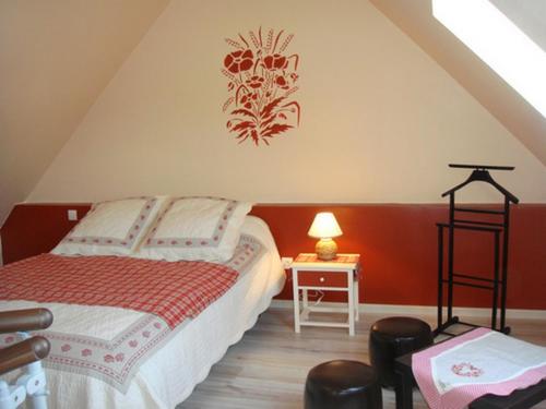 een slaapkamer met een bed en een tafel met een lamp bij les coquelicots in Nibas