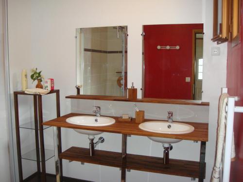 La salle de bains est pourvue de 2 lavabos et d'un grand miroir. dans l'établissement les coquelicots, à Nibas