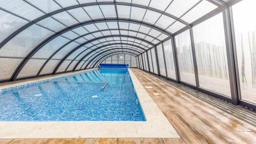 an indoor swimming pool with a glass ceiling at Baltic Sun, Sun & Snow in Sztutowo