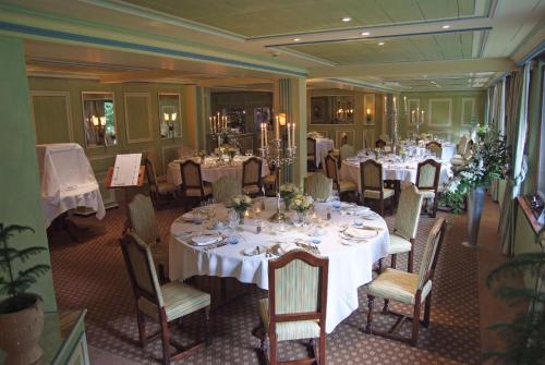 a dining room with white tables and chairs at Waldhotel Doldenhorn in Kandersteg