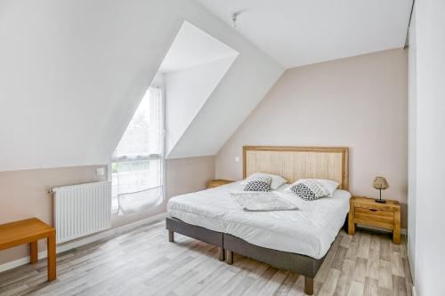 une chambre blanche avec un lit et une fenêtre dans l'établissement L'Exploratrice, à Saint-Lunaire