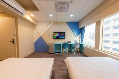 an empty hospital room with two beds and a desk at Liu He Su Hotel in Kaohsiung