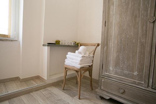 a stack of towels on a chair in a room at Colosseo Apartments and Rooms - Rome City Centre in Rome