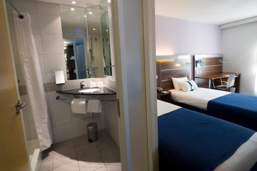 a hotel room with two beds and a shower at Holiday Inn Express Marseille Saint Charles, an IHG Hotel in Marseille