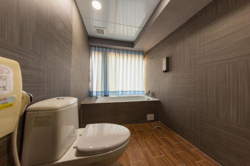 a bathroom with a toilet and a bath tub at Liu He Su Hotel in Kaohsiung