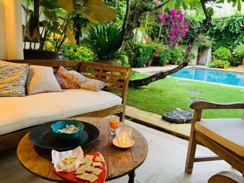 a living room with a couch and a table with food on it at Villa Kunang in Seminyak