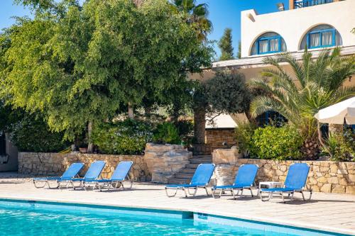 a row of blue lounge chairs next to a swimming pool at Navarria Blue Hotel in Limassol