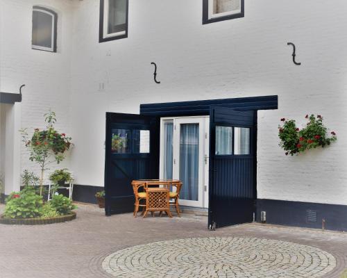 a building with a blue door and a wooden chair at De Oude Limonadefabriek in Beek