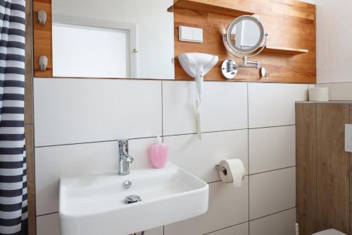 a bathroom with a sink and a mirror at Pension Laubenhof in Mörbisch am See
