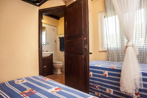 a bedroom with a bed and a toilet and a bathroom at Villa Stella in Santa Margherita di Pula