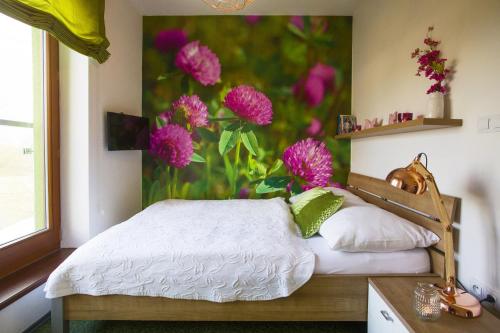 a bedroom with a painting of flowers on the wall at Design Hotel Romantick in Třeboň