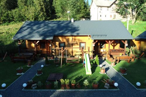an aerial view of a log cabin with a playground at Drewniany Domek Daria i Tomek 2 domki na 8 osób in Stronie Śląskie