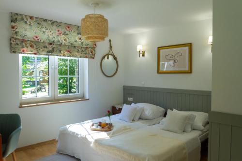 a bedroom with a large white bed with a window at Biały Domek in Purda