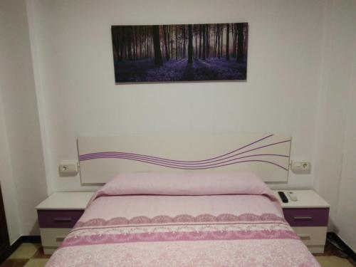 a bedroom with a bed with two nightstands and a painting at CASA DE ONIL in Onil