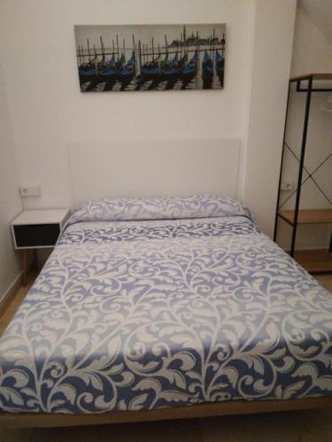 a bed with a blue and white comforter in a room at CASA DE ONIL in Onil