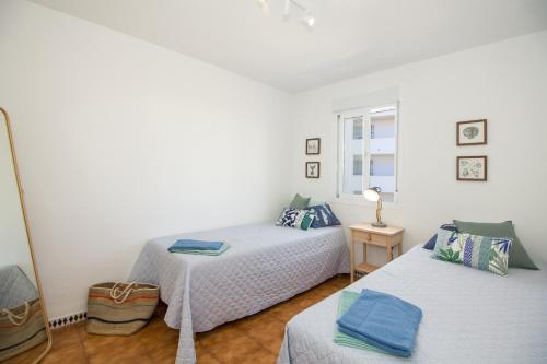 une chambre avec deux lits et une fenêtre dans l'établissement A cozy and elegant townhouse across the beach, à Torre de Benagalbón