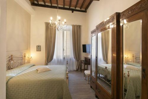 Casa Mavì- Siena في سيينا: غرفة نوم بسريرين توأم ومرآة