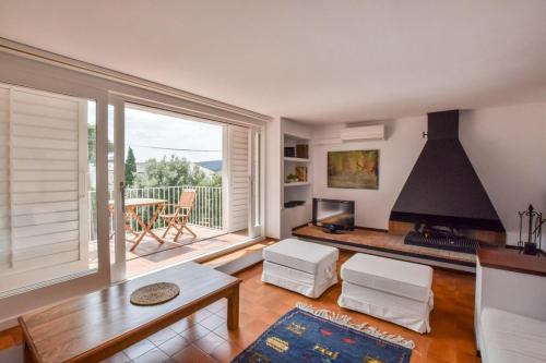 a living room with a fireplace and a large window at CENTRIC APARTMENT CADAQUES -private parking - CA L'ELLA in Cadaqués