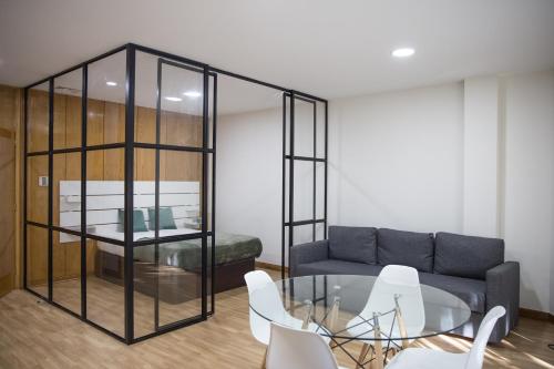 a living room with a couch and a glass table at Estúdio Corujeira in Porto
