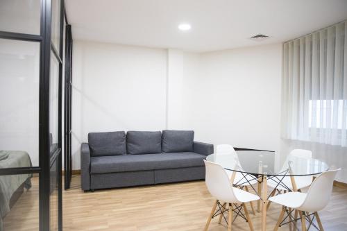 a living room with a glass table and a couch at Estúdio Corujeira in Porto