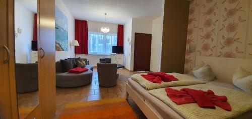 a bedroom with two beds and a living room at Pension Lenz in Sassnitz