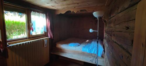 a small room with a bed and a lamp in it at Agriturismo Alagna in Alagna Valsesia