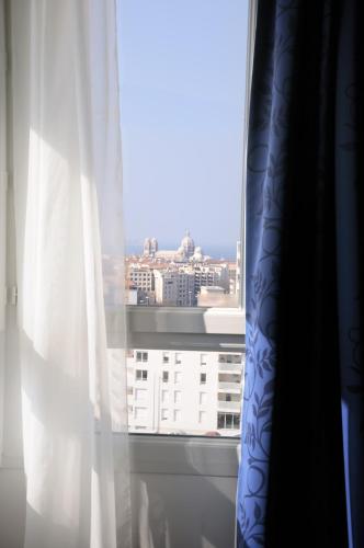 a window with a view of a building at Hôtel Marseille Centre Gare Saint-Charles in Marseille
