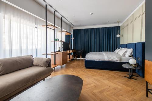 a living room with a bed and a couch at Moncafe Boutique Hotel & SPA Tirana in Tirana