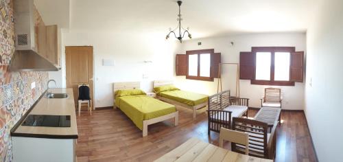 Sala de estar con 2 camas y mesa en Apartamentos Rurales Rad Icarium en Radiquero