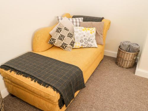 a couch with pillows on it in a room at Manor House Farm Cottage in Saltburn-by-the-Sea