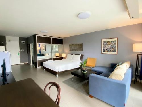 a living room with a bed and a couch at The Studio at Sathorn Terrace in Bangkok