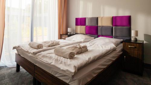 a large bed with towels on it in a bedroom at Termy Warmińskie in Lidzbark Warmiński