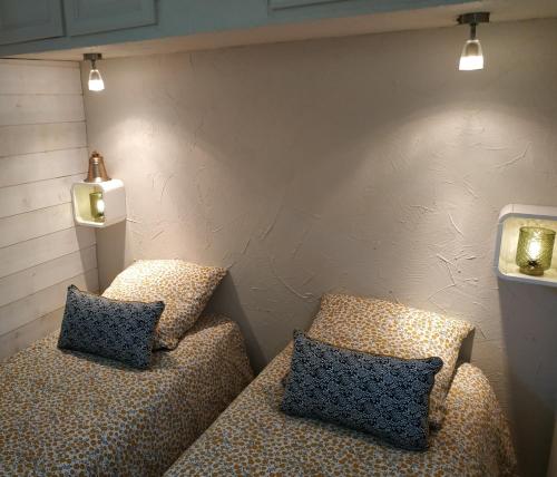 deux lits dans une chambre avec des lumières sur le mur dans l'établissement Charmant appartement à 350m de la plage et du port, à Fréjus