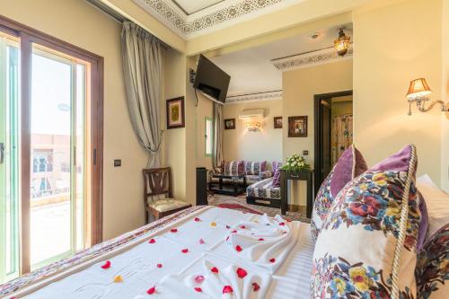 a bedroom with a bed and a living room at Le Caspien Boutique Hotel in Marrakech