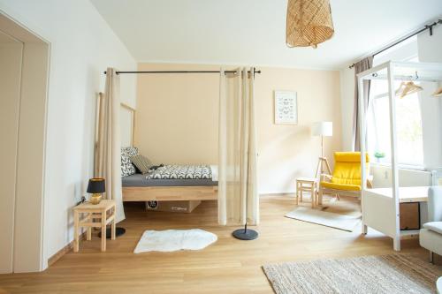 um quarto com uma cama e uma cadeira num quarto em FULL HOUSE Premium Apartments - Halle Südstadt em Halle an der Saale