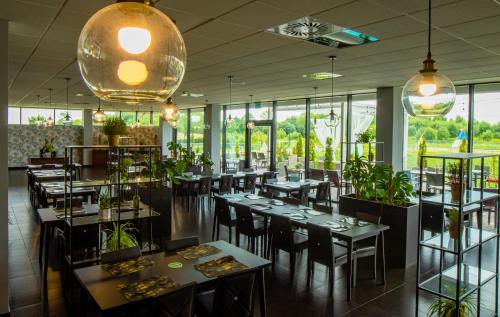 a restaurant with tables and chairs and large windows at Termy Warmińskie in Lidzbark Warmiński