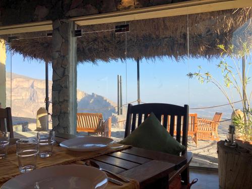 a dining table with a view of the mountains at SAMA Al Khutaim-Heritage Home in Nizwa